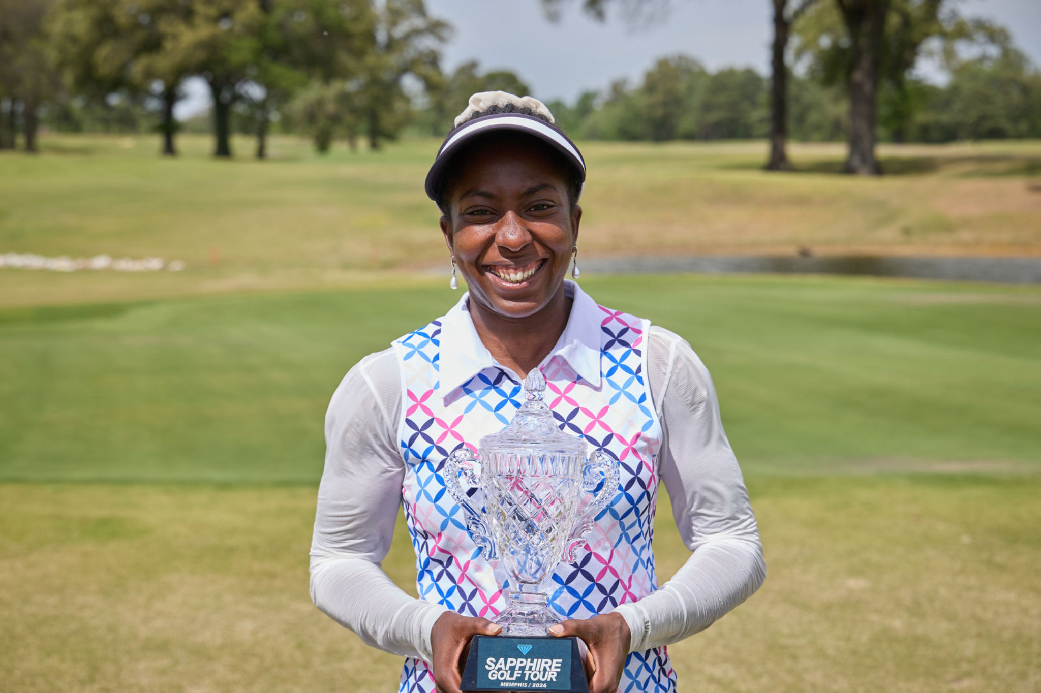 Memphis Sapphire Golf Tour champion holding her trophy on the course