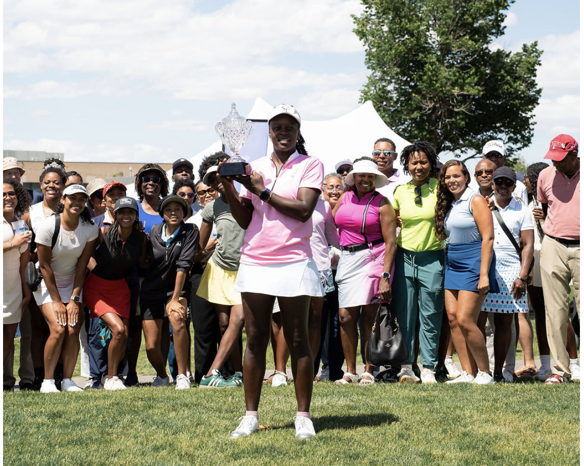 A golfer holding a trophy with Sapphire players and supporters